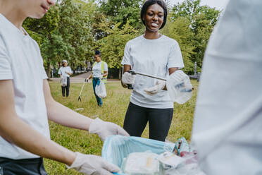 Umweltschützerinnen und Umweltschützer sammeln Plastikmüll im Park auf - MASF27351