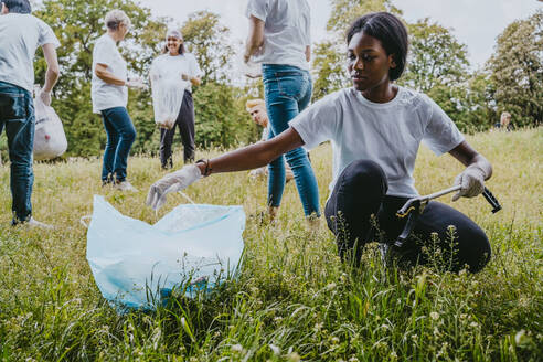 Junge Umweltschützerin sammelt Plastikmüll im Park auf - MASF27358