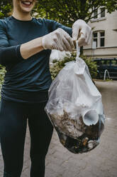 Mittelteil einer weiblichen Freiwilligen, die eine Plastiktüte hält - MASF27391