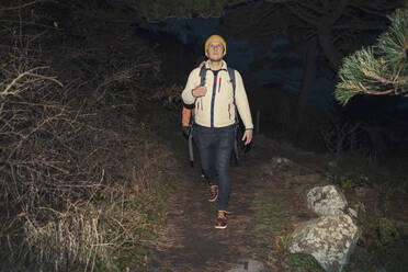 Mature man hiking in forest at night during vacation - MASF27456