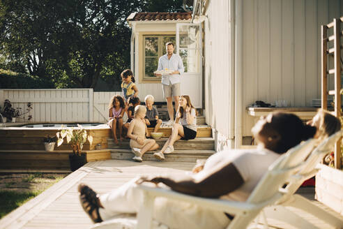 Familie verbringt Freizeit auf der Terrasse an einem sonnigen Tag - MASF27478