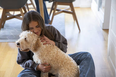 Mädchen umarmt Hund zu Hause - MASF27500