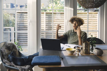 Teenage boy talking while studying through video call on laptop at home - MASF27529