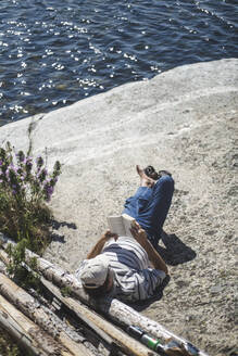 High angle view of man reading book at island on sunny day - MASF27587