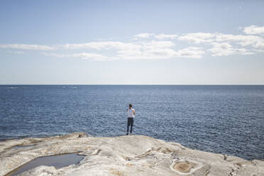 Rear view of man admiring sea on sunny day - MASF27591