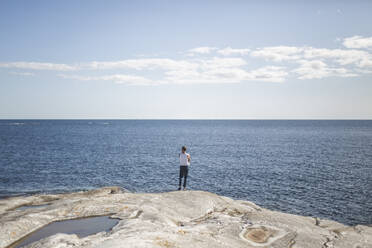 Rückansicht eines Mannes, der das Meer an einem sonnigen Tag bewundert - MASF27591