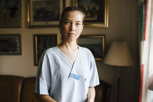 Portrait of female nurse in living room at home - MASF27675