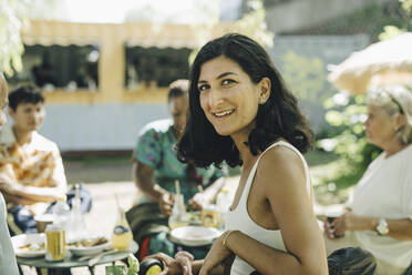 Lächelnde Frau, die Kunden beim Essen auf der Straße sitzen hat - MASF27766