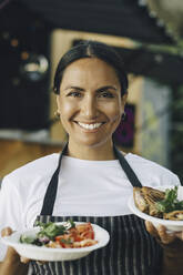 Portrait of smiling female owner with food - MASF27798
