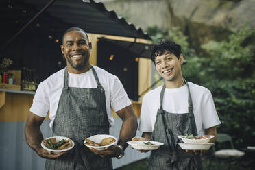 Portrait of male colleagues with food by truck - MASF27804