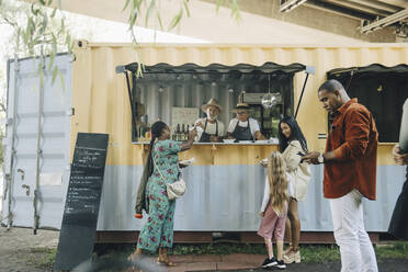 Senior male and female entrepreneurs selling street food to customers - MASF27806