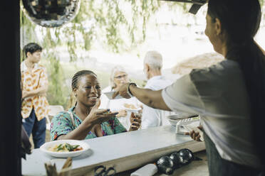 Eine Verkäuferin serviert einem Kunden im Park Essen - MASF27827