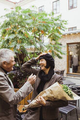 Fröhliches älteres Paar im Gespräch in einem Straßencafé in der Stadt - MASF27847