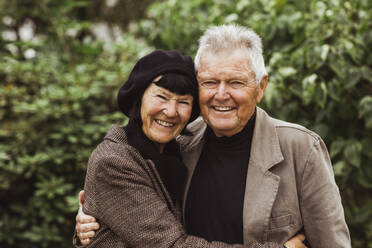 Portrait of happy senior couple embracing in park during weekend - MASF27872