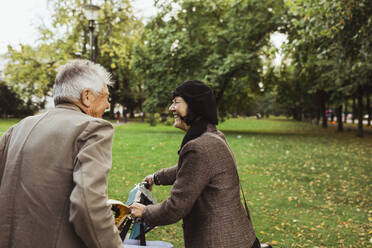 Glückliches älteres Paar verbringt seine Freizeit mit einem Elektrofahrrad im Park - MASF27887