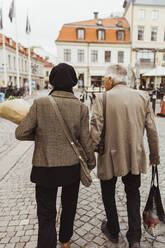 Rückansicht eines älteren Paares auf der Straße in der Stadt - MASF27896