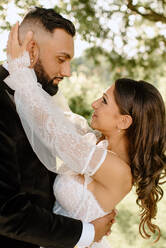 Bride and groom embracing in park - ISF25478
