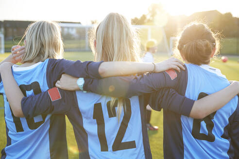UK, Rückansicht von Fußballspielerinnen (10-11, 12-13), die sich auf dem Feld umarmen - ISF25495