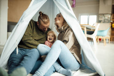 Playful family enjoying inside tent at home - GUSF06672