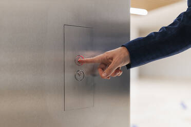 Businessman using elevator push button - JRVF02232