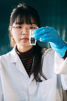 Young scientist doing experiment with liquid solution in laboratory - ASGF01870