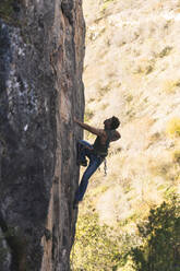 Hiker climbing on rock mountain - JAQF01009