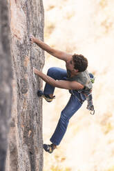 Active hiker climbing rock mountain - JAQF01012