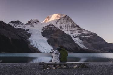 Ein Paar vor dem Mount Robson über dem Bergsee in der Morgendämmerung. - MINF16473