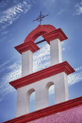 Architektonisches Detail, rot-weiße Farbe und Eisenkreuz auf einem Kirchendach in Cancun. - MINF16482