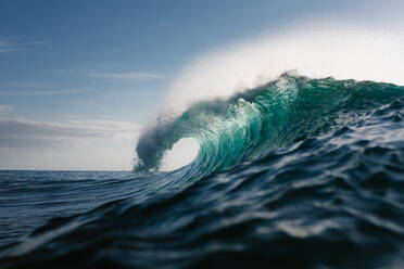 Powerful foamy sea waves rolling and splashing over water surface against cloudy blue sky - ADSF32753