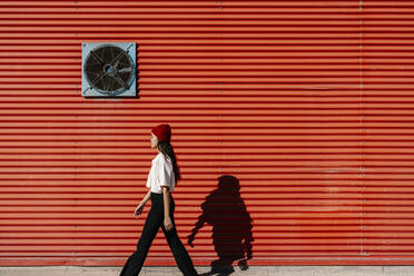 Young woman walking on footpath - EGAF02468