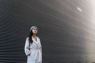 Thoughtful woman in front of black corrugated wall - EGAF02500