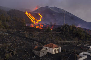 Luftaufnahme eines Hauses mit dem Vulkan Cumbre Vieja im Hintergrund, ein Vulkan während eines Ausbruchs in der Nähe der Stadt El Paraiso, Las Manchas, Insel La Palma, Kanarische Inseln, Spanien. - AAEF13601