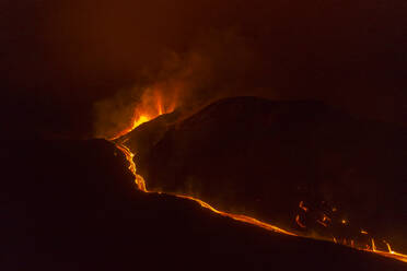 Aerial top down view of lava floating down the Volcan Cumbre Vieja at night, a volcano during eruption near El Paraiso town, Las Manchas, La Palma Island, Canary Islands, Spain. - AAEF13602