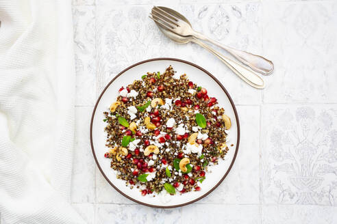 Studioaufnahme eines Tellers mit Quinoa-Salat mit Feta-Käse, Granatapfelkernen und Cashewnüssen - LVF09176