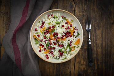 Studioaufnahme einer Schüssel Blumenkohlsalat mit Granatapfelkernen, Pistazien, Minze, Petersilie und Aprikose - LVF09186