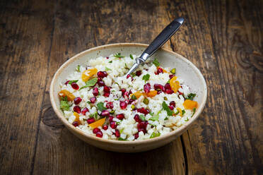 Studioaufnahme einer Schüssel Blumenkohlsalat mit Granatapfelkernen, Pistazien, Minze, Petersilie und Aprikose - LVF09187