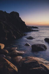 View of rocky coastline at dusk - RAEF02451