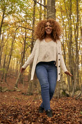 Happy young woman enjoying weekend in autumn forest - VEGF05230