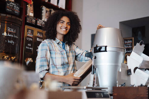 Kaffeeröster mahlt Kaffee im Laden - KNSF09194