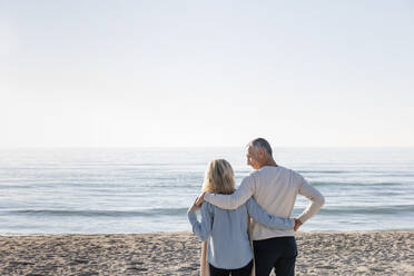 Man looking at woman standing together at beach - EIF02558