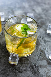Glass of refreshing drink with lime, mint and ice cubes - GIOF14368