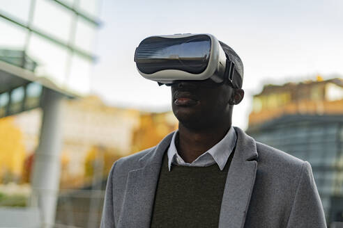 Geschäftsmann mit Virtual-Reality-Headset in der Stadt - GIOF14403