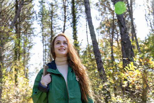 Nachdenkliche Frau schaut beim Wandern im Wald weg - EIF02667