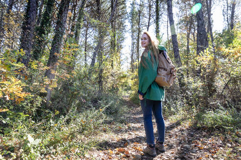 Junge Frau beim Wandern im Wald an einem sonnigen Tag - EIF02668
