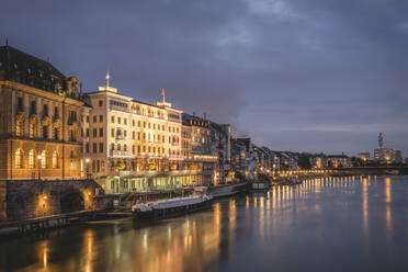 Schweiz, Basel-Stadt, Basel, Städtische Uferpromenade bei Nacht von der Mittleren Brücke aus gesehen - KEBF02075