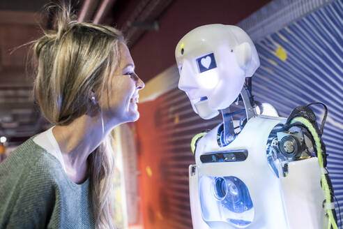 Technikentwickler lächelt vor menschlichem Roboter beim Workshop - WESTF24750