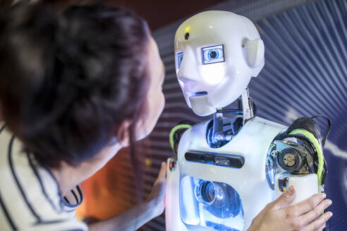Technischer Entwickler sieht sich menschlichen Roboter in der Werkstatt an - WESTF24765