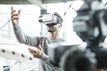 Tech developer wearing virtual reality headset at robotic workshop - WESTF24798