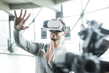 Developer with virtual reality headset gesturing at workshop - WESTF24799